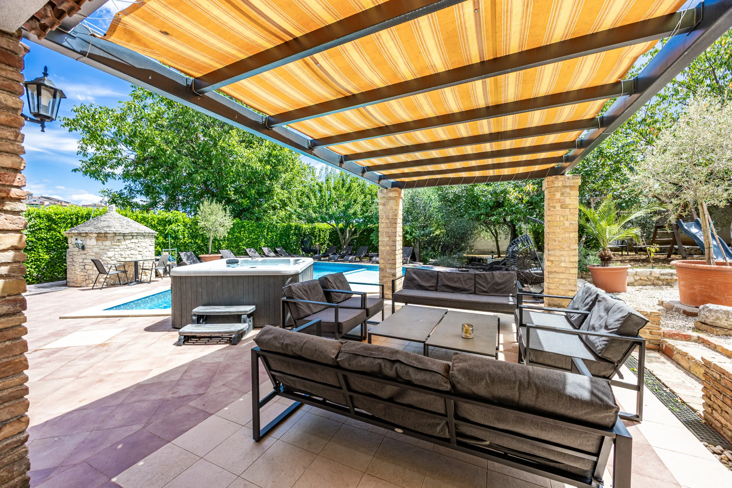 Cushioned sofas and chairs set out under the pergola