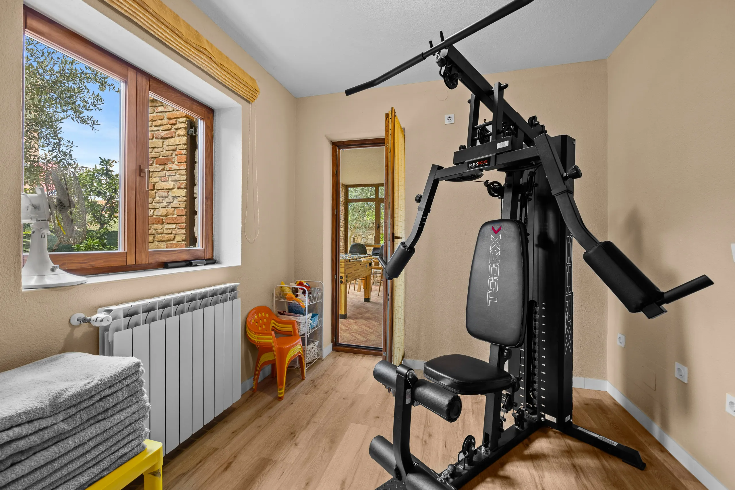 The gym's multi-station machine, with an olive tree framed in the window