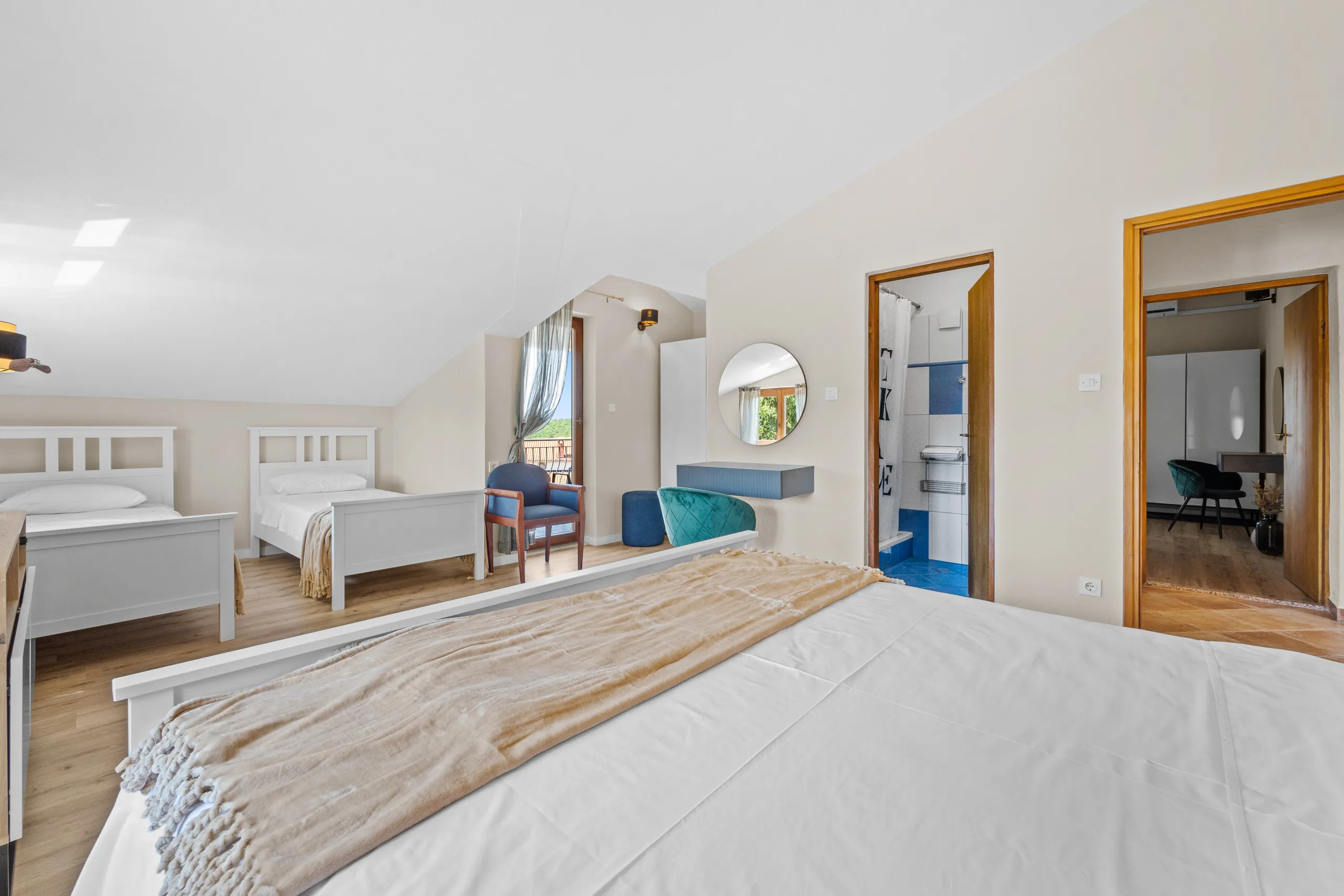 A split-level room with a double bed, two singles on the upper floor and a tiled shower room off it