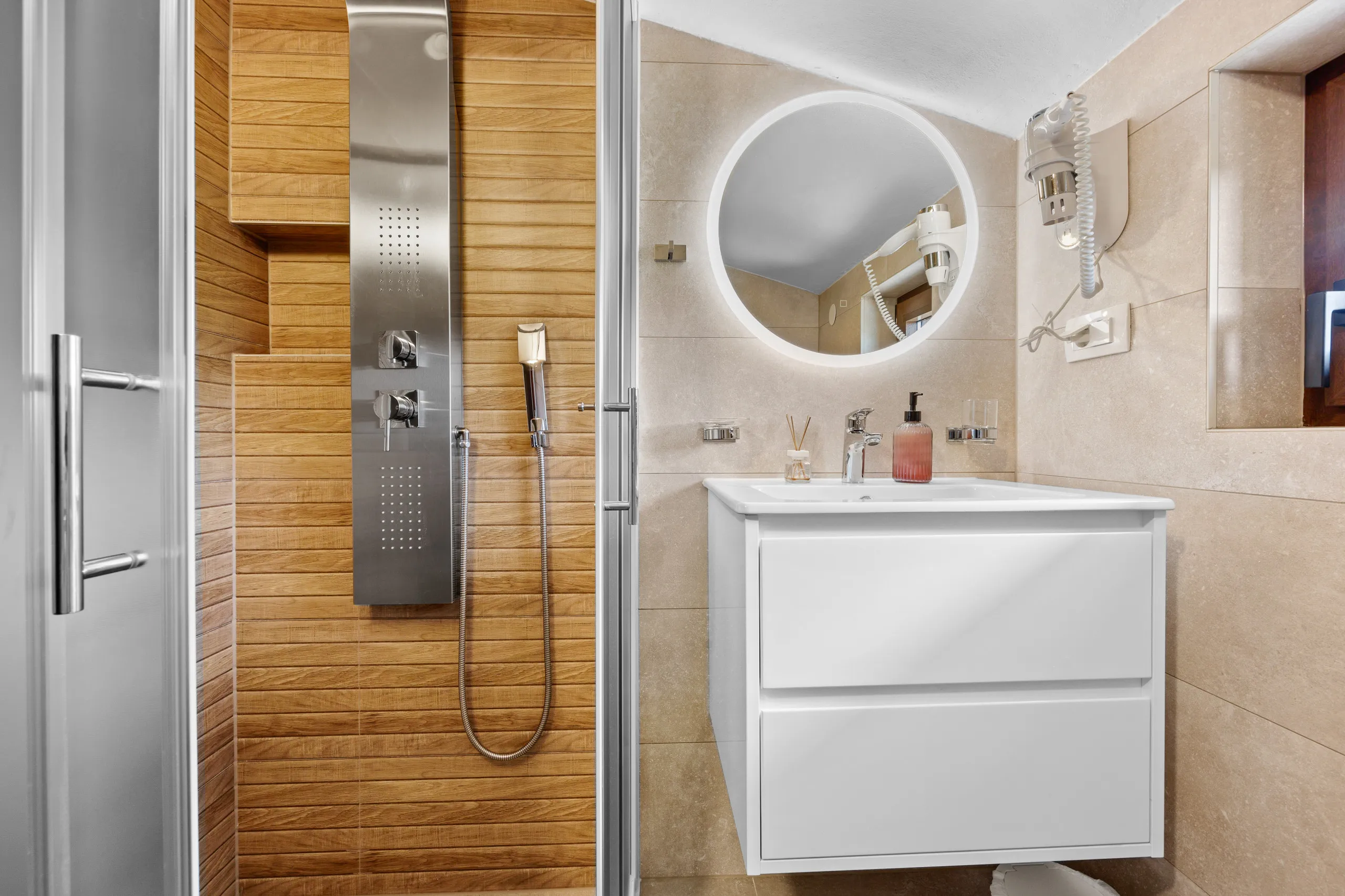 Bathroom with a double vanity, walk-in shower and wood-panelled wall